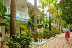 una mujer caminando por una calle en frente de un edificio en Legends Beach Resort en Negril