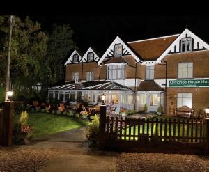 une maison avec une clôture devant elle la nuit dans l'établissement Ormonde House Hotel, à Lyndhurst