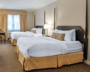 una camera d'albergo con due grandi letti con lenzuola bianche di The Century House, an Ascend Collection Hotel a Latham Altre 36 foto