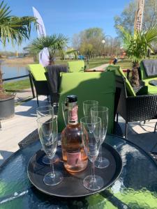taca z dwoma kieliszkami i butelką na stole w obiekcie Waterfront Lodge w mieście Dunapataj