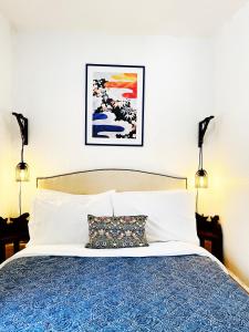 a bedroom with a bed with a blue and white bedspread at Old Barrel Store - Old Town. Parking & Garden in Margate