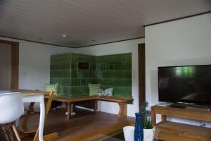 a living room with a flat screen tv and a table at Zur alten Oele - Hochwertig und Familienfreundlich in Lenzkirch