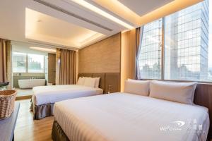 two beds in a hotel room with a large window at Wow Happy- Taipei in Taipei