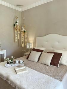 - une chambre avec un lit blanc et un livre dans l'établissement Giardini di Marzo, à Felline
