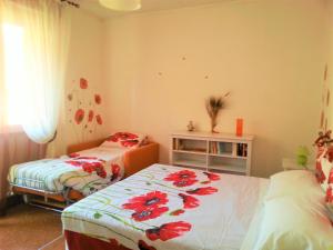 um quarto com duas camas com flores vermelhas em il Papavero em Recco