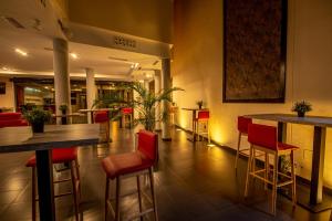 restauracja z czerwonymi krzesłami i stołami w holu w obiekcie Hotel Los Nardos w mieście Chipiona