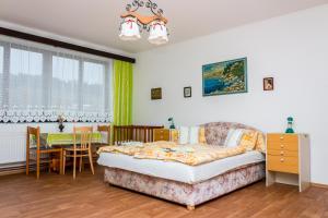 a living room with a bed and a dining room at Pension u Josefa in Košťálov