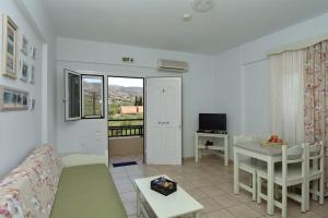 een woonkamer met een bank en een tafel bij Bonos apartments in Stoupa
