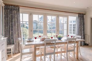 a dining room with a table and chairs and windows at 3 The Coastguards Thorpeness Air Manage Suffolk in Leiston