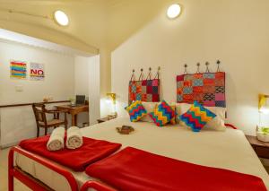 1 dormitorio con 1 cama grande con manta roja en goSTOPS Kochi, en Kochi