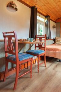 een kamer met 2 stoelen en een tafel en een bed bij De Wagen in Egmond-Binnen