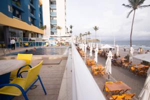 a resort with a pool and tables and chairs and the ocean at FLAT O POINT do CARNAVAL do FAROL da BARRA in Salvador