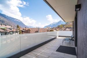 a balcony of a house with a view of mountains at Apartment Anemone - GriwaRent AG in Interlaken