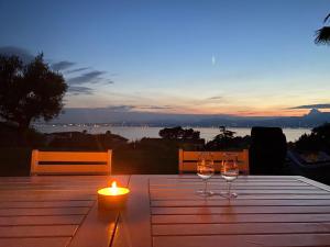 un tavolo con due bicchieri da vino e una candela di Lovely villa Elena - Garda Lake a Bardolino