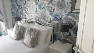 um quarto com uma cama com papel de parede azul e branco em No 6 Quality Guesthouse em Llandudno