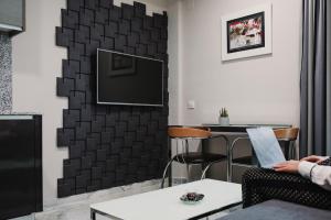 a living room with a tv on a wall at Citizentral Gascons in Valencia
