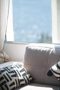 Sofá con almohada frente a una ventana en Villa Les Glycines, en Les Issambres