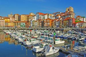 a group of boats docked in a harbor with buildings at Apartamento con encanto "ZIRIMIRI" in Bermeo