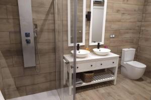 a bathroom with two sinks and a shower at Apartamento con encanto "ZIRIMIRI" in Bermeo