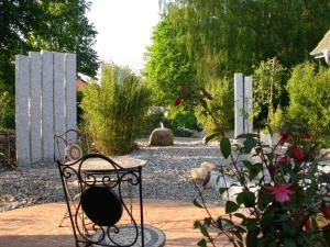 un jardín con una silla en un patio de ladrillo en Modernes 5-Sterne-Ferienhaus im Maisonettenstil in DAMP, en Damp
