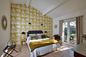 ein Schlafzimmer mit einem Bett und einer gelben und weißen Wand in der Unterkunft Les Mazets de Marie de Jules in Eyragues