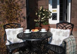 a black table with two chairs and a plate of food at Furain in Peterculter +22 photos