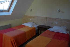 two beds in a room with a window at Gîtes du Manoir de Goandour in Crozon