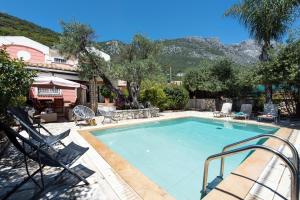 uma grande piscina com cadeiras e uma casa em Villa Palmier em Ano Pyrgi