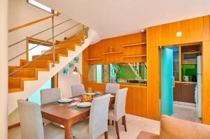 ein Esszimmer mit einem Tisch, Stühlen und einer Treppe in der Unterkunft Stunning Townhouse With Pool In Tavira Centre in Tavira