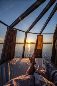 a person laying on a bed on a boat in the water at Laponia Sky Hut in Gällivare