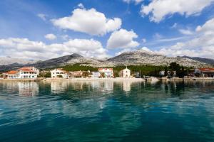 a body of water with houses and mountains in the background at Villa Fontana in Starigrad-Paklenica