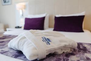 a white towel laying on top of a bed at Maritim Antonine Hotel & Spa in Mellieħa