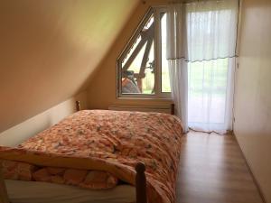 Schlafzimmer mit einem Bett und einem großen Fenster in der Unterkunft Pressoir du bois gribout in Hautot-Saint-Sulpice