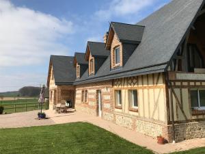Pressoir du bois gribout في Hautot-Saint-Sulpice: منزل من الطوب كبير مع سقف أسود