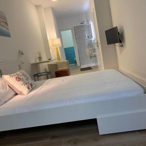 a bedroom with a large white bed in a room at Sa Conca holiday in Cagliari
