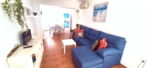 a living room with a blue couch and a tv at Apartamento Villananitos in San Pedro del Pinatar