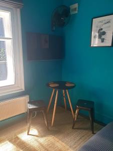 een tafel en twee stoelen in een kamer met een blauwe muur bij Room eleven in Veliko Tŭrnovo