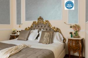una camera da letto con letto dotato di testiera e cuscini dorati di Hotel Bernini Palace a Firenze