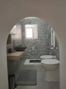 uma casa de banho com um lavatório, um WC e uma janela. em Casa Cavaliere em Perugia