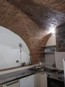 cocina con pared de ladrillo y fregadero en Casa Cavaliere en Perugia