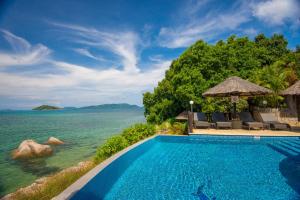 una piscina del resort con vista sull'oceano di Chalets Cote Mer a Baie Sainte Anne