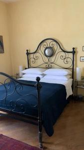 a bedroom with a black bed with white pillows at SPINETO HOUSE in Spineto Scrivia +86 photos