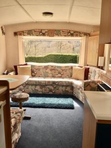 a living room with a couch and a large window at Forest View - Adults Only - Maximum 2 Guests in Drumnadrochit