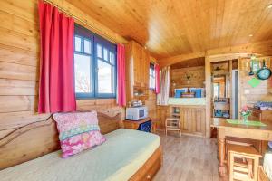 - une chambre avec un lit dans une cabane en bois dans l'établissement Domaine des Cadets de Gascogne, à Pauilhac