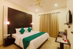 Schlafzimmer mit einem großen Bett mit einem Kopfteil aus Holz in der Unterkunft Hotel Citizen New Delhi in Neu-Delhi