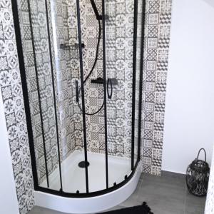 a shower with a black and white shower curtain at Apartament w Pieninach in Krościenko