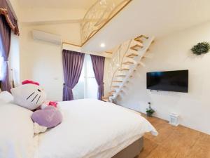 ein Schlafzimmer mit einem weißen Bett und einer Treppe in der Unterkunft Mu river Villa 慕河包棟休閒別墅 in Wujie