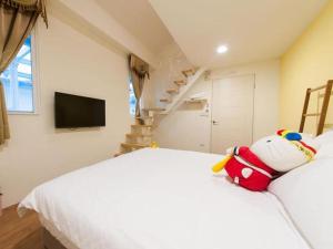 un osito de peluche sentado en una cama en un dormitorio en Mu river Villa 慕河包棟休閒別墅 en Wujie