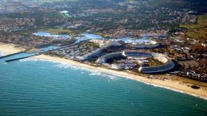 een luchtzicht op een strand met een stadion bij Chambre La Palmeraie village naturiste in Cap d'Agde