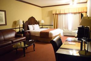 a hotel room with a bed and a couch at Folk Inn Ontario Airport in Ontario